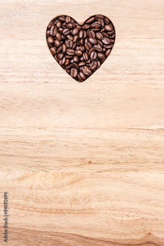 Heart shaped coffee beans on wooden board