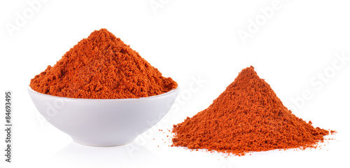 Powdered dried red pepper in a white bowl on white background