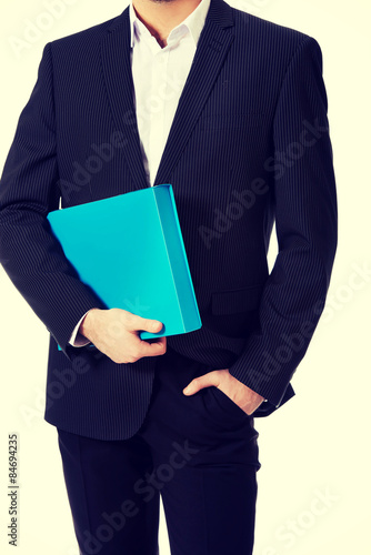 Handsome businessman holding a binder.