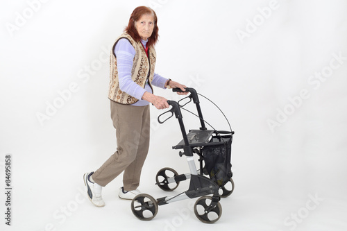 Elderly lady walking with a walking  frame, rollator..