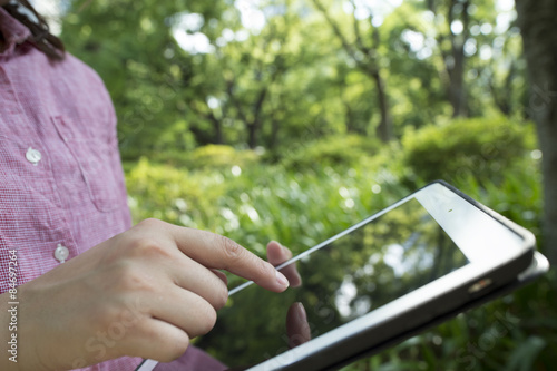 Women are using a tablet outdoors