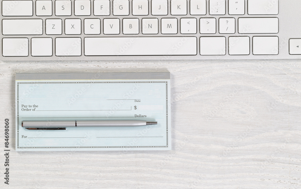 © tab62 - Blank checkbook with pen on white desktop