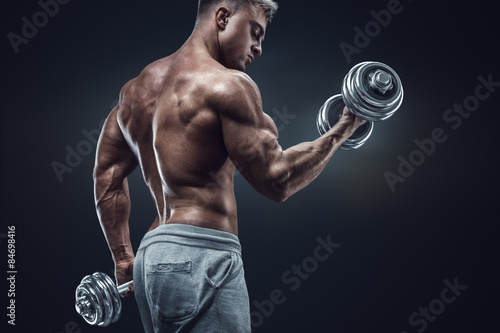 Closeup portrait of a muscular man workout with barbell at gym