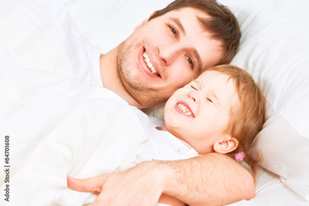 Happy family father and child baby daughter sleeping in bed Happy family father and child baby daughter sleeping in bed