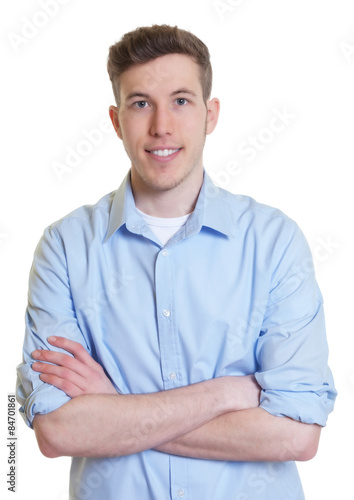 Lässiger junger Mann im hellblauen Hemd mit verschränkten Armen