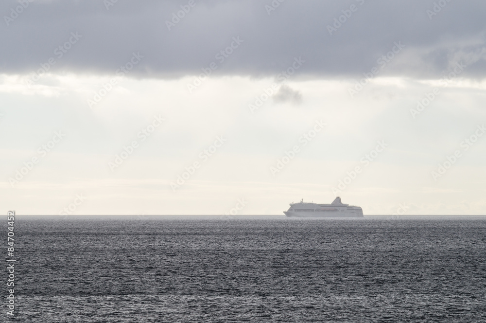 Vanishing cruise ship in haze of blue water