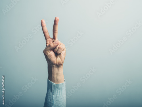 Male hand displayin victory sign photo