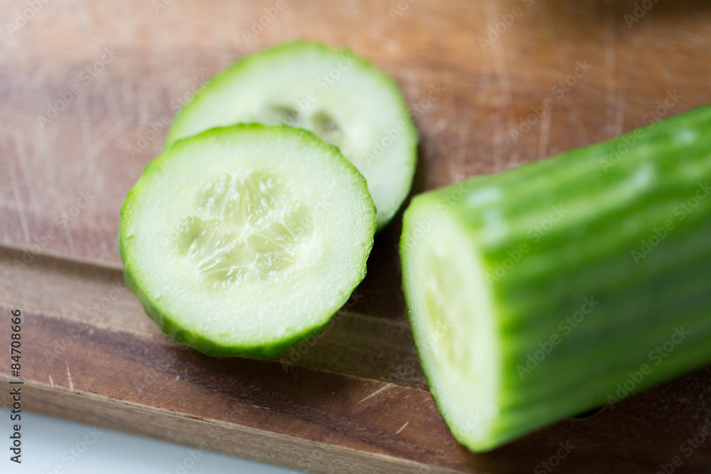 close up of cucumber on wooden cutting board close up of cucumber on wooden cutting board
