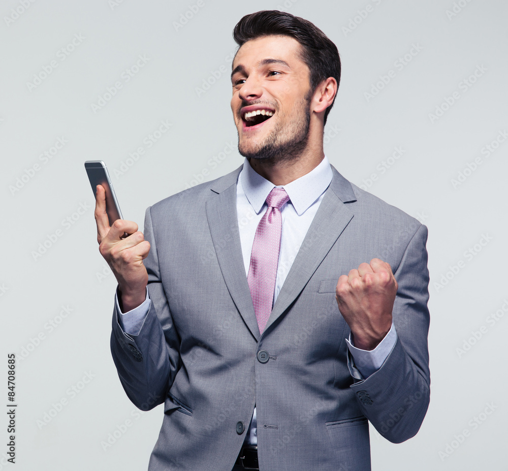 Cheerful businessman holding smartphone Cheerful businessman holding smartphone