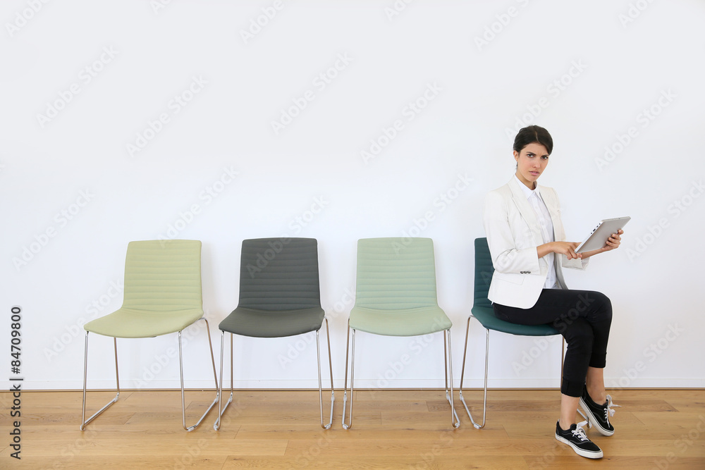 Woman in waiting room using digital tablet, concept Woman in waiting room using digital tablet, concept