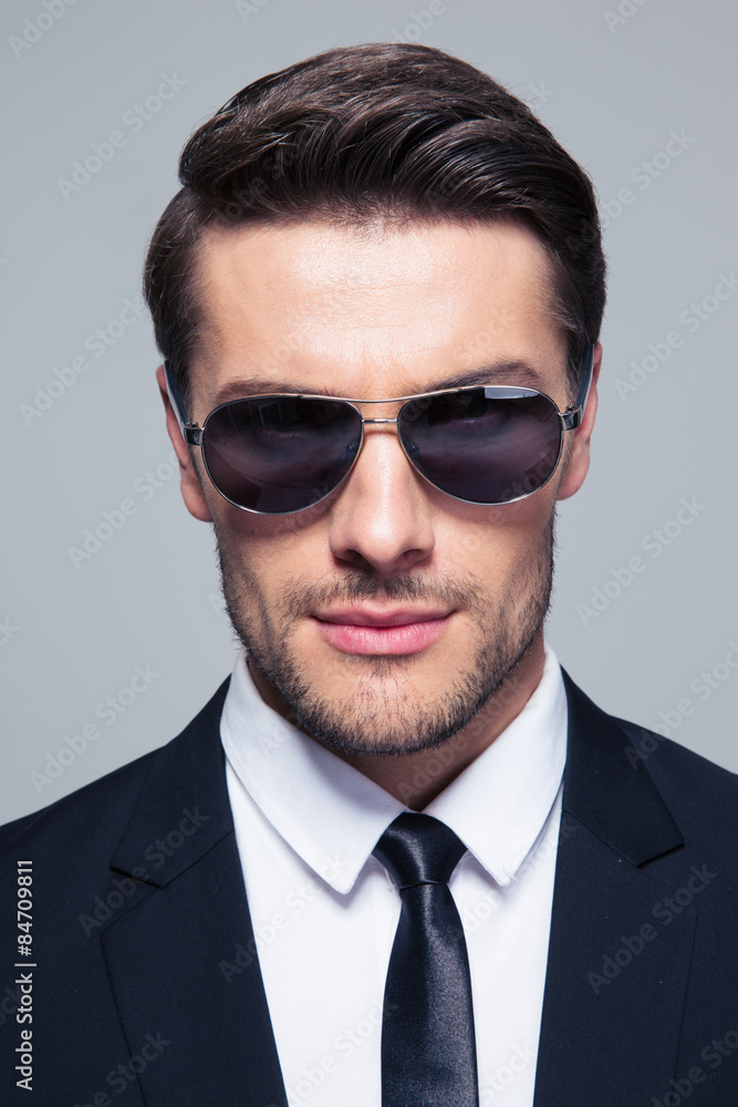 Businessman in sunglasses looking at camera