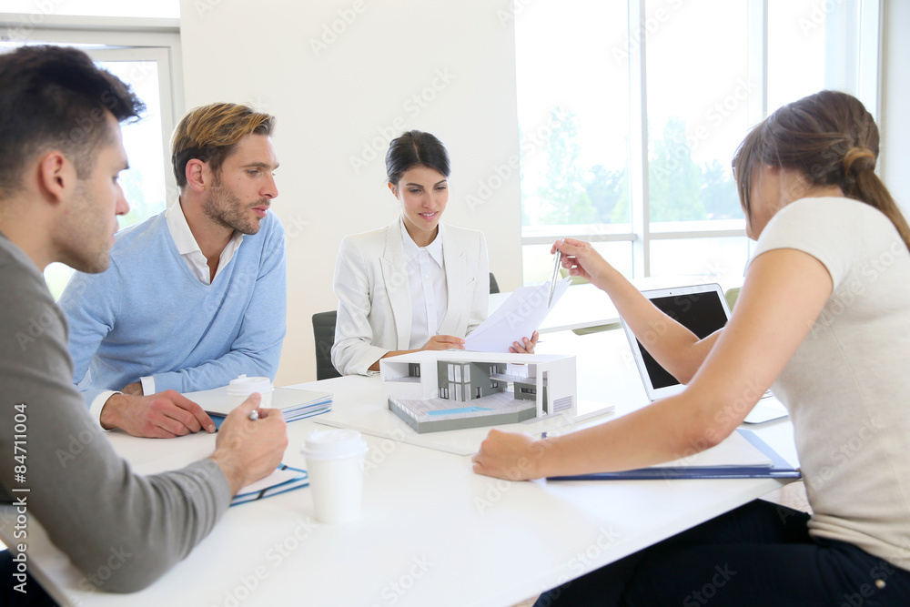 Team of architects meeting around table to talk about project Team of architects meeting around table to talk about project