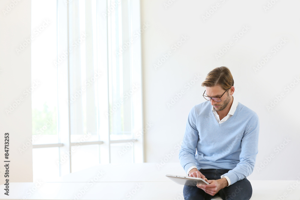 Man sitting on table, connected on digital tablet, white background Man sitting on table, connected on digital tablet, white background