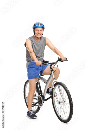 Senior with a blue helmet posing on a bicycle
