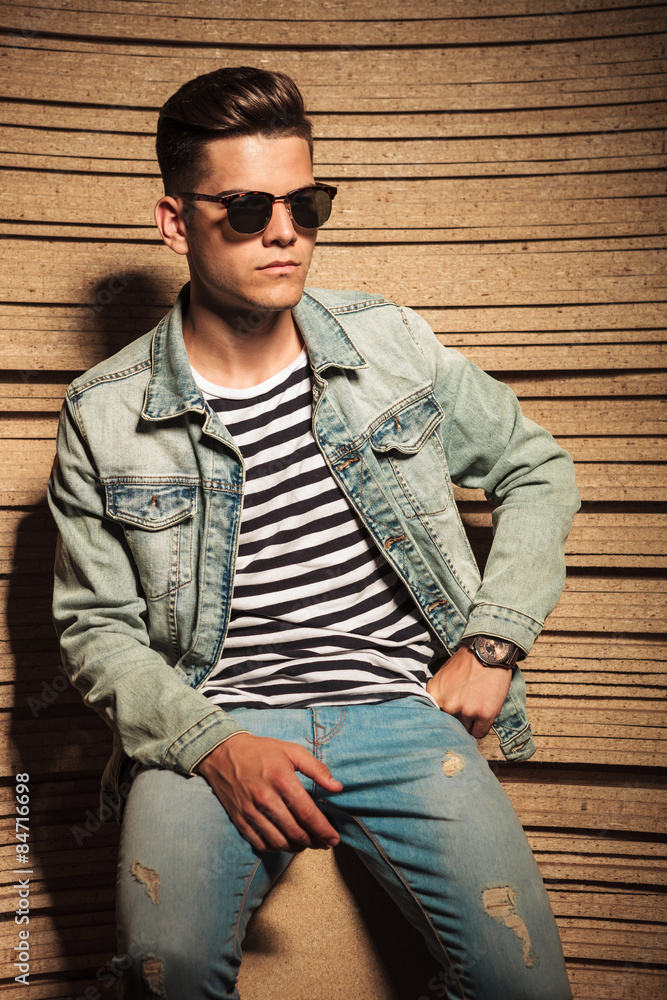 cool man in jeans jacket and sunglasses sits cool man in jeans jacket and sunglasses sits