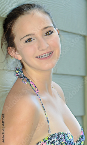 A pretty teenage girl in bikini smiling happily showing her braces. Stock  Photo | Adobe Stock