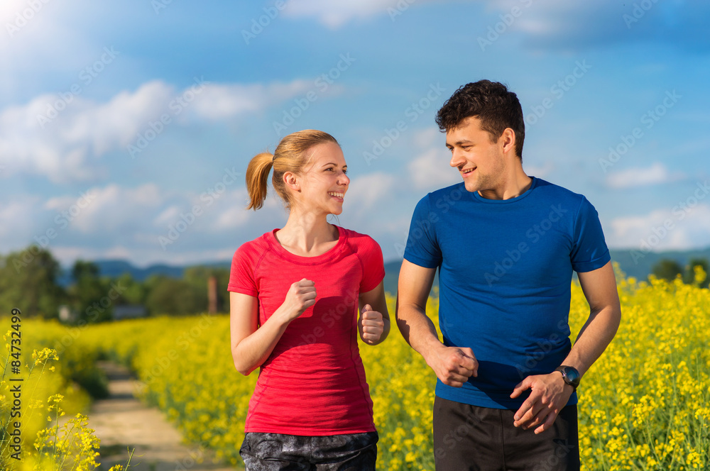 Beautiful young runners outside in canola field