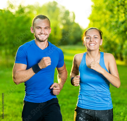 Fototapeta Naklejka Na Ścianę i Meble -  Runners training outdoors working out. City running couple