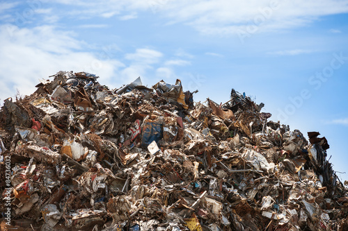 Scrap metal ready for recycling over blue sky.