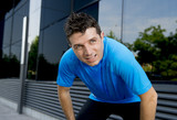 young attractive man leaning exhausted after running session sweating taking a break to recover in urban street