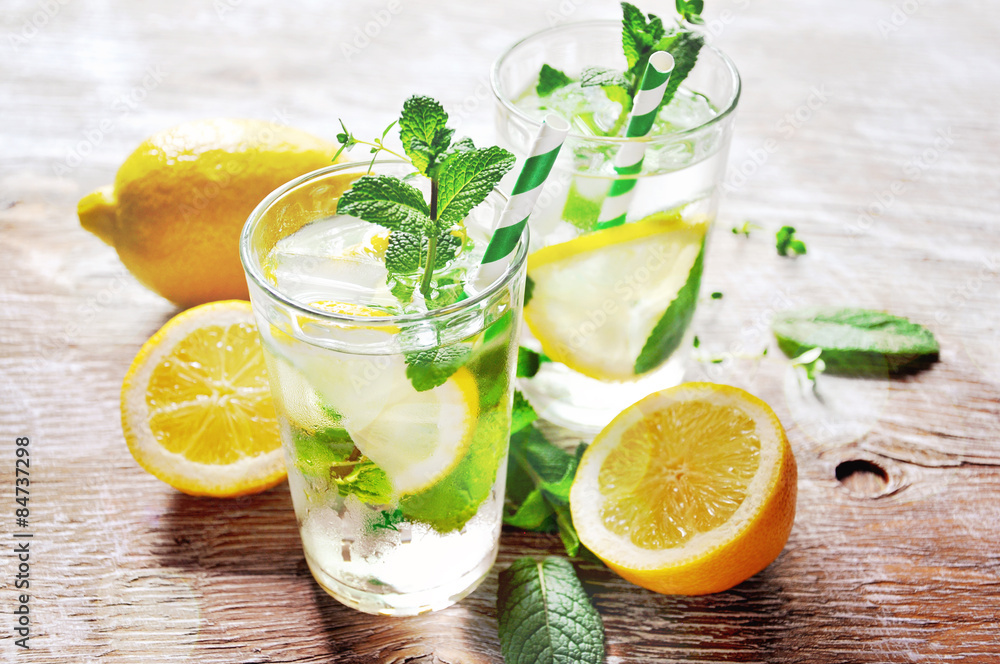 Refreshing cold iced mint tea with lemons, summer drink with ice Refreshing cold iced mint tea with lemons, summer drink with ice