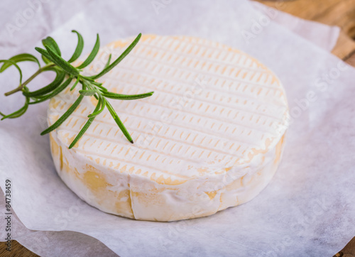 Traditional Camembert with rosemary on white paper