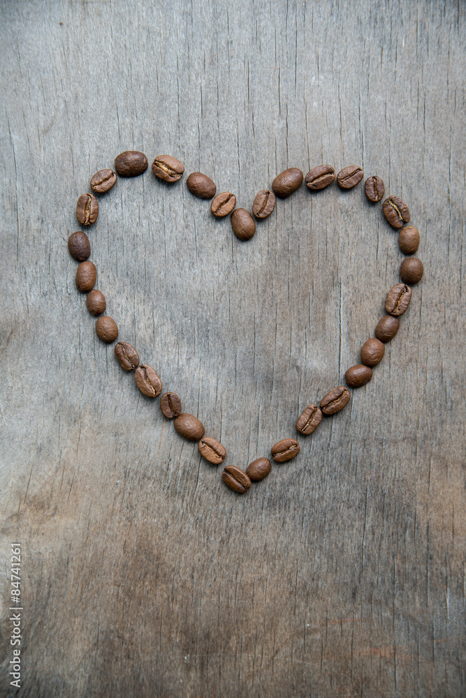 Heart of coffee beans on wooden background Heart of coffee beans on wooden background