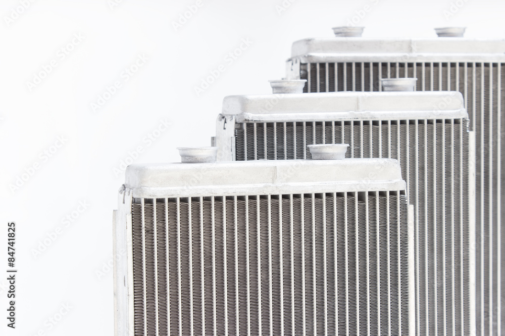 Fototapeta premium three new automotive radiator stove on a gray background