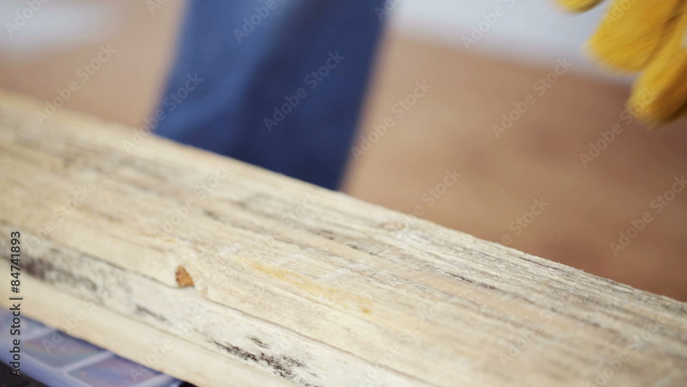 close up of man hammering nail to wooden board close up of man hammering nail to wooden board