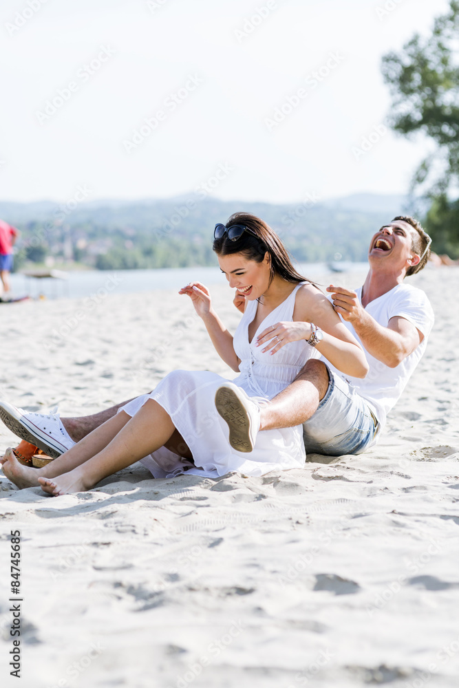 Fototapeta premium Romantic young couple sitting at a beach