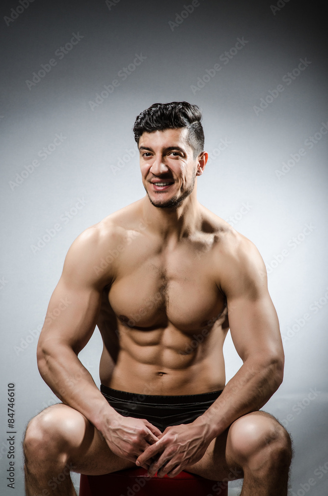 Fototapeta premium Muscular man posing in dark studio