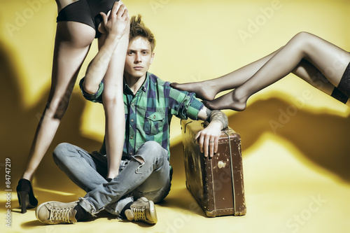 Young casanova man with suitcasen amd female legs