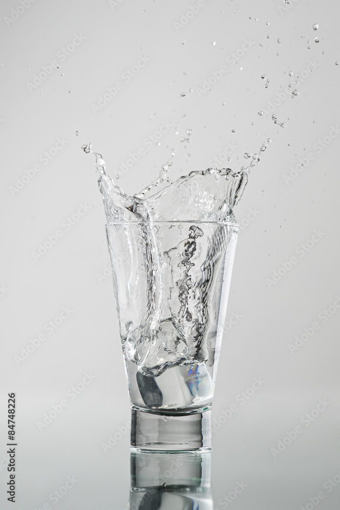 Splash com gelo caindo no copo de água Splash com gelo caindo no copo de água