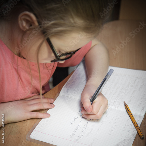 Girl make written lessons.