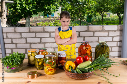 Quadro su tela Girl at Table with Vegetables and Preserves