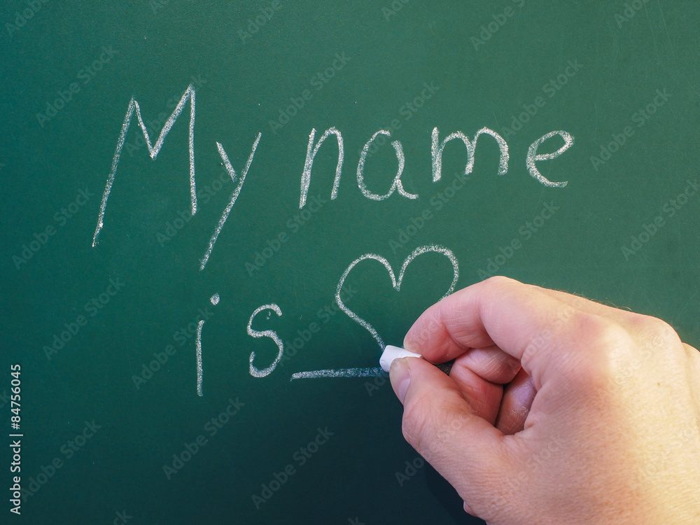Person writing on green chalkboard with calk Person writing on green chalkboard with calk