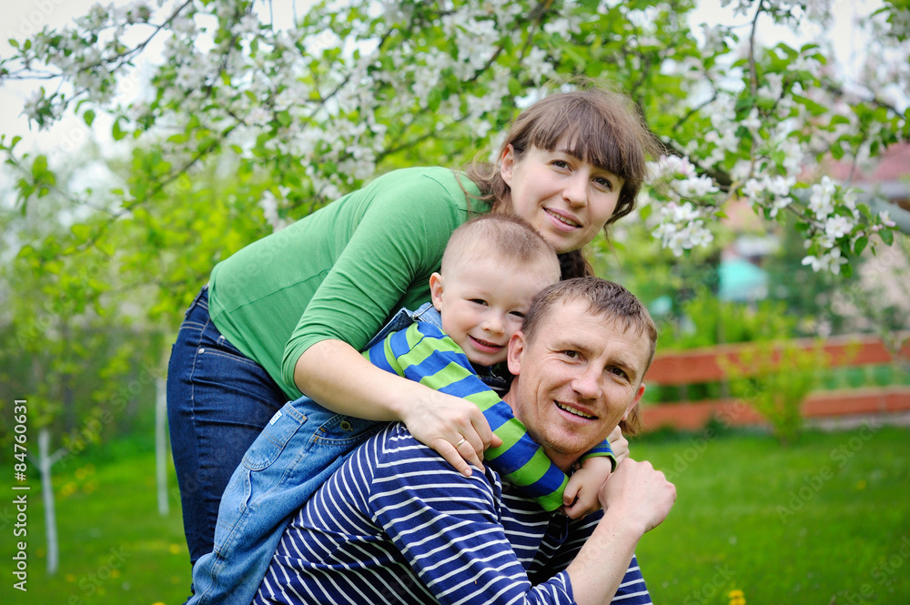 young family walks in the spring garden with a child young family walks in the spring garden with a child