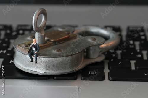 Internet security concept-miniature businessman stand on old key