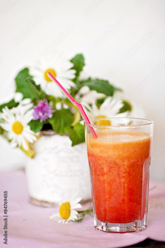 Strawberry, orange and apple fresh in a glass with a lined straw Strawberry, orange and apple fresh in a glass with a lined straw