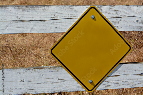 Yellow Street Sign on the Fence