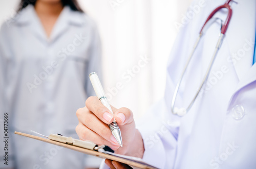 doctor writing patient’s record after examine health