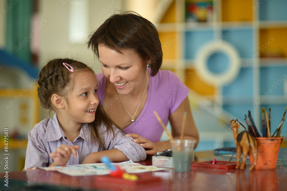 Little girl painting with mother Little girl painting with mother