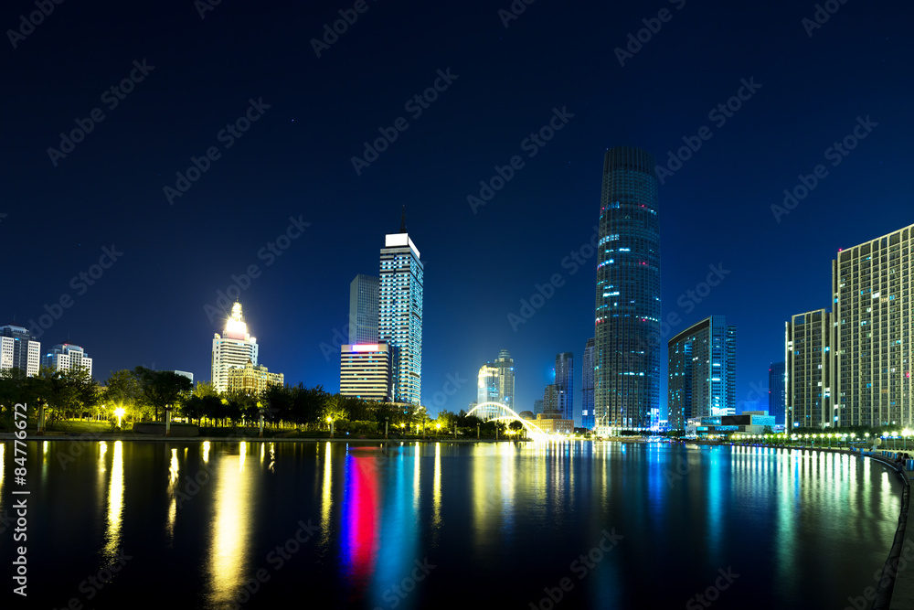 Fototapeta premium Illumintaed modern skyscrapers and skyline at riverbank