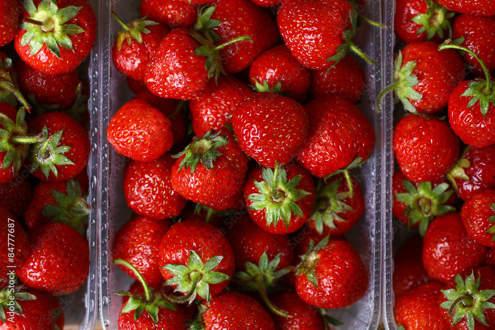 Fresh strawberries in a plastic bowl on wooden background Fresh strawberries in a plastic bowl on wooden background