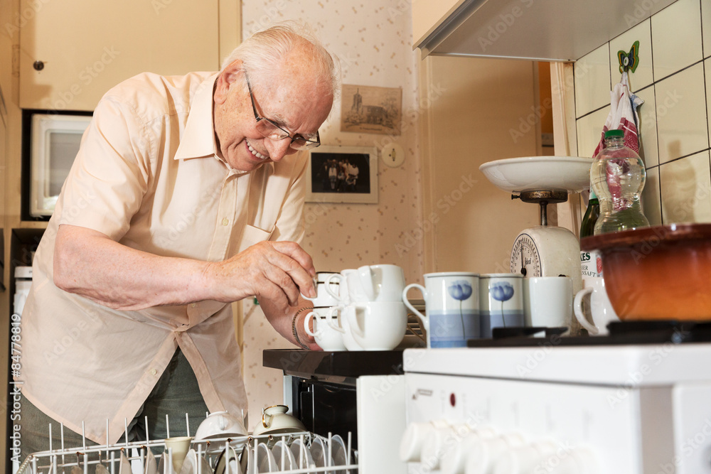 Elderly man unloading the dishwasher Stock Photo Adobe Stock