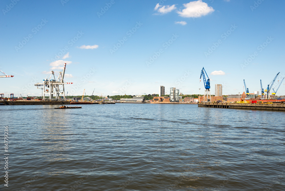 Motor barge on the river Elbe in the harbor of Hamburg. In the background the new skyline with the high rise buildings at the famous Altona Fish market