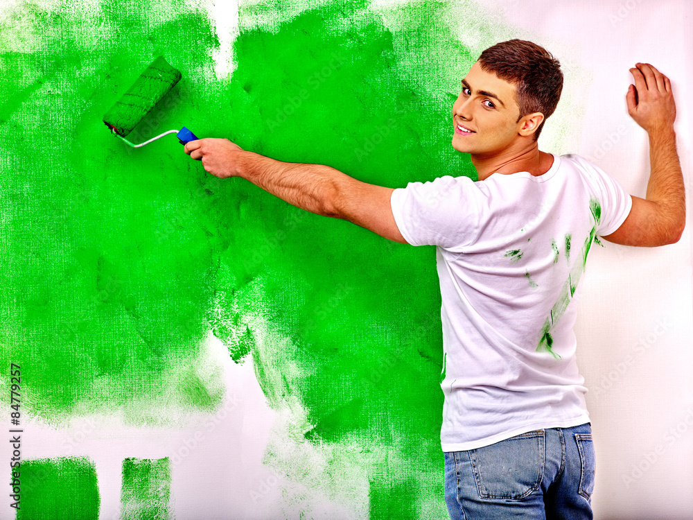Obraz premium man paint wall at home.