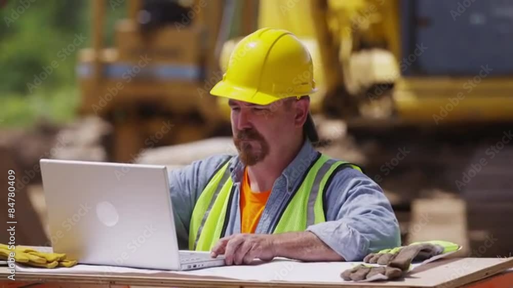 Construction worker using laptop computer Construction worker using laptop computer