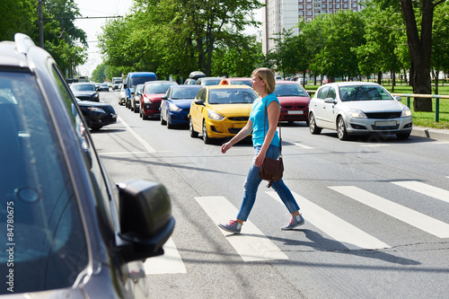 Fotografie, Obraz Woman crossing street at pedestrian crossing