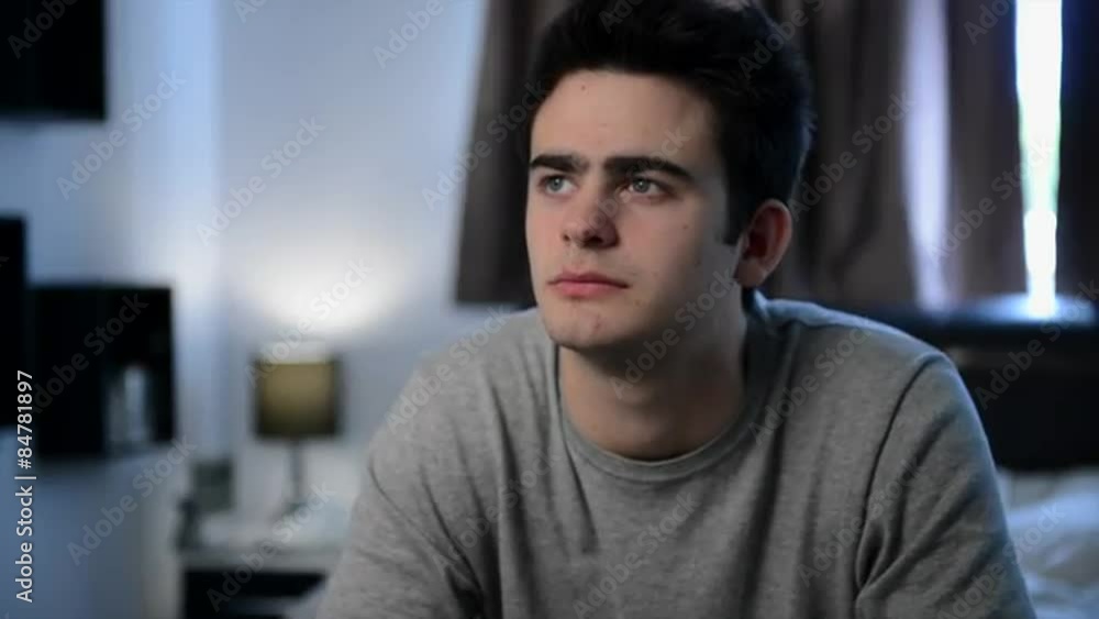 Close up portrait of depressed teenage boy in his bedroom Close up portrait of depressed teenage boy in his bedroom